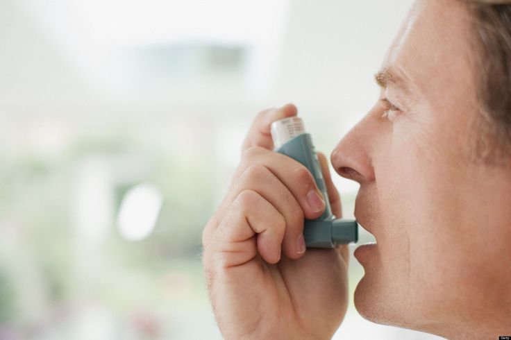 Man using a metered-dose asthma inhaler